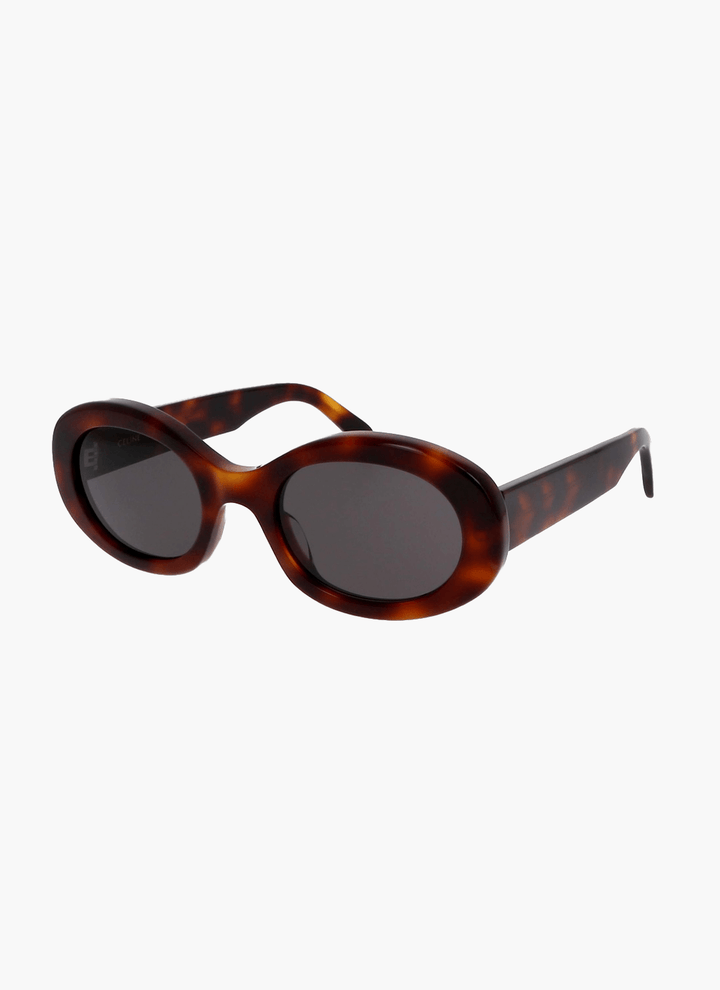 A woman wearing retro oval vintage sunglasses on a sunny day out.