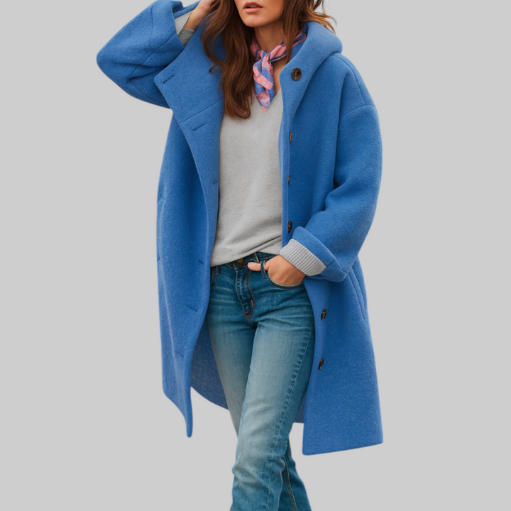 A woman wearing a hooded mid-length coat with wood-look buttons, hands in the side pockets.