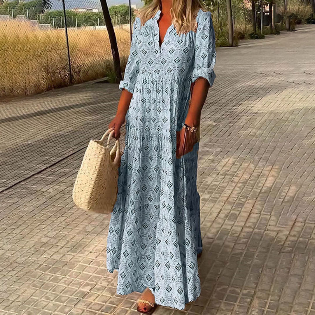 Woman wearing the Monica™ elegant boho maxi dress with a V-neckline and flowing skirt at a summer occasion.