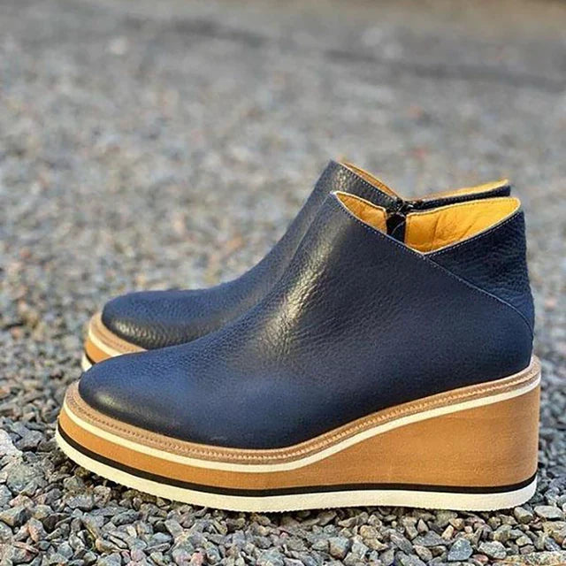 A woman wearing sleek minimalist ankle boots with jeans on a city break.