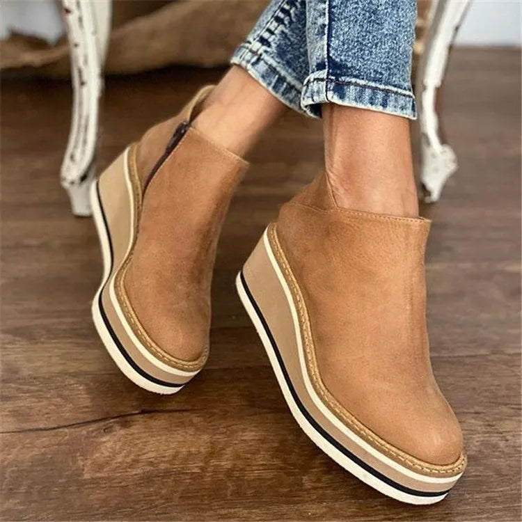 A woman wearing sleek minimalist ankle boots with jeans on a city break.
