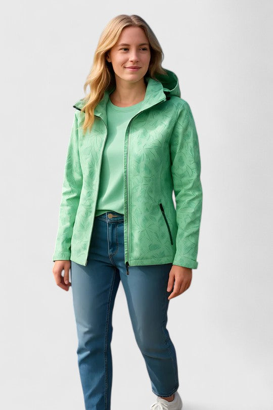 A woman wearing a botanical leaf-print jacket with a hood outdoors