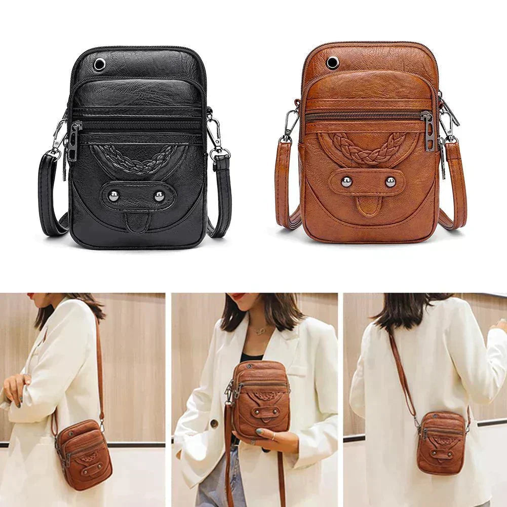 A small brown crossbody bag with a plaited front detail and zip pockets on a wooden stump.