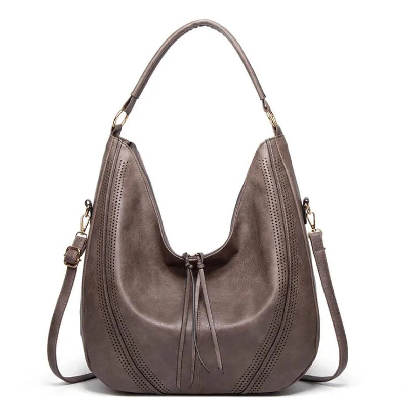 A woman holding a soft grey casual handbag over her shoulder on a relaxed day out.
