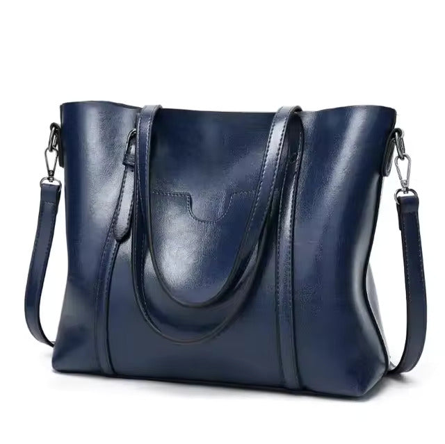 A woman carrying a structured luxe handbag on her arm while out for the day.