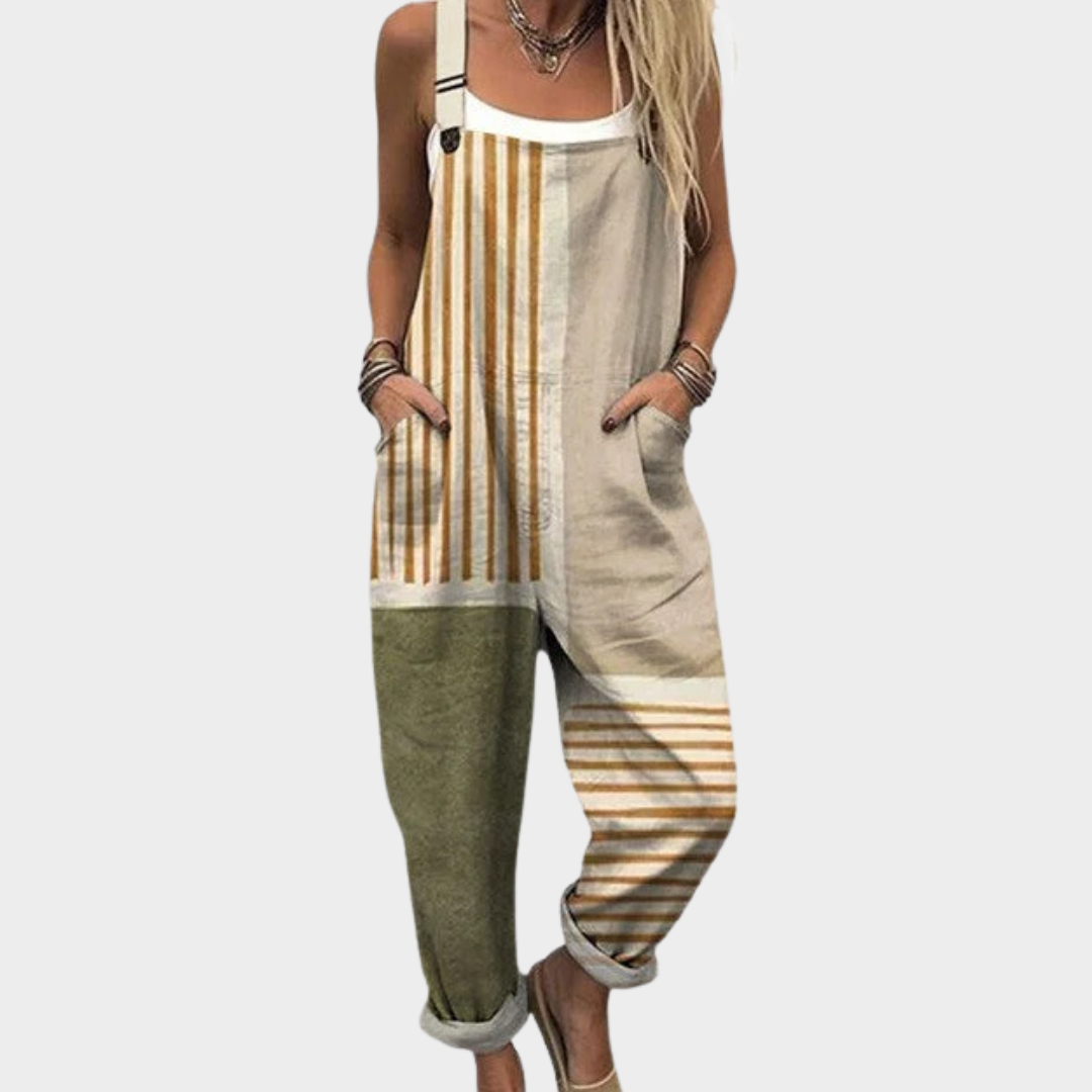 Woman wearing beige and olive vertical-striped overalls with adjustable straps, relaxed and at ease.