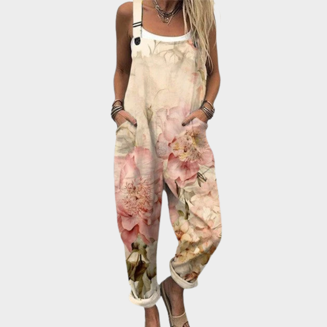 Woman wearing cream overalls with soft pink watercolour roses, adjustable straps, relaxed and graceful.