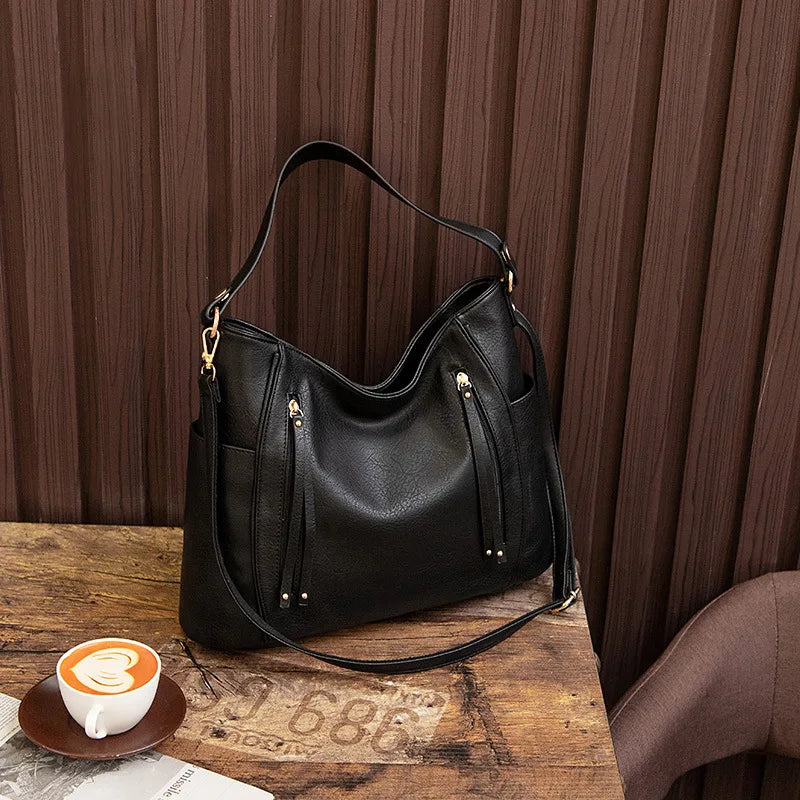 A woman wearing a fringed shoulder bag that sways gently as she walks through town.