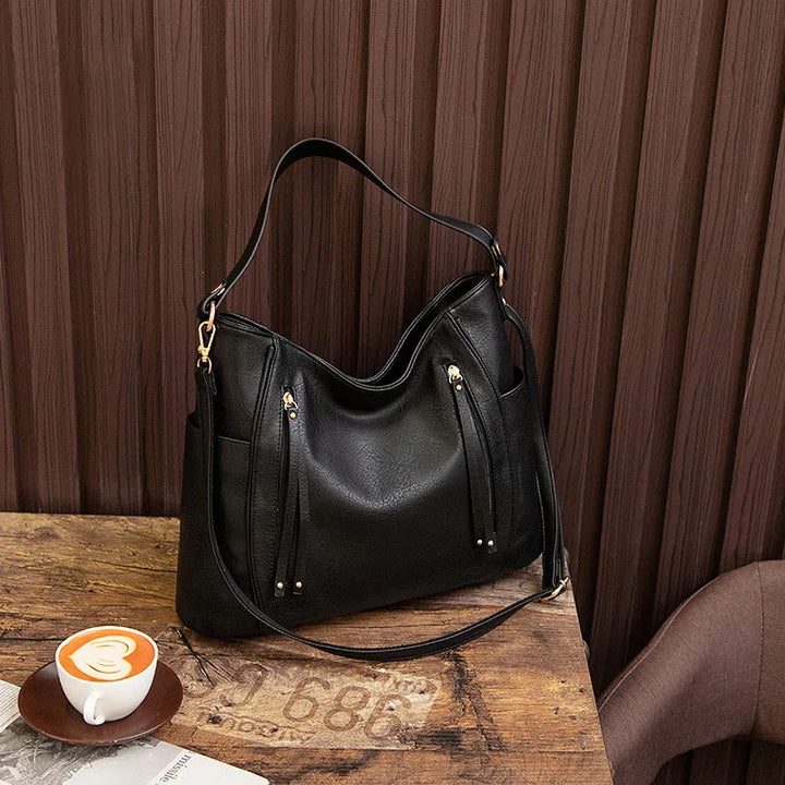 A woman wearing a fringed shoulder bag that sways gently as she walks through town.