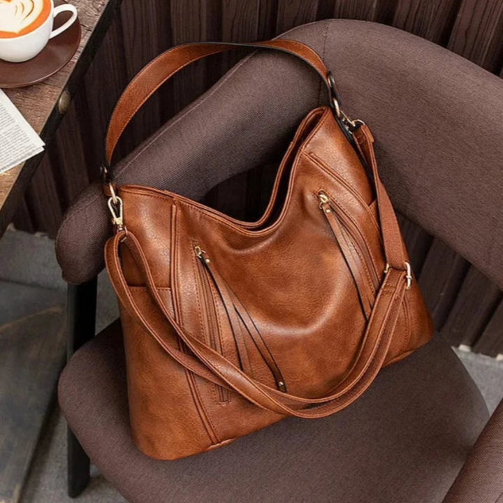 A woman wearing a fringed shoulder bag that sways gently as she walks through town.