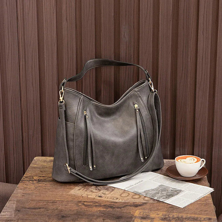 A woman wearing a fringed shoulder bag that sways gently as she walks through town.