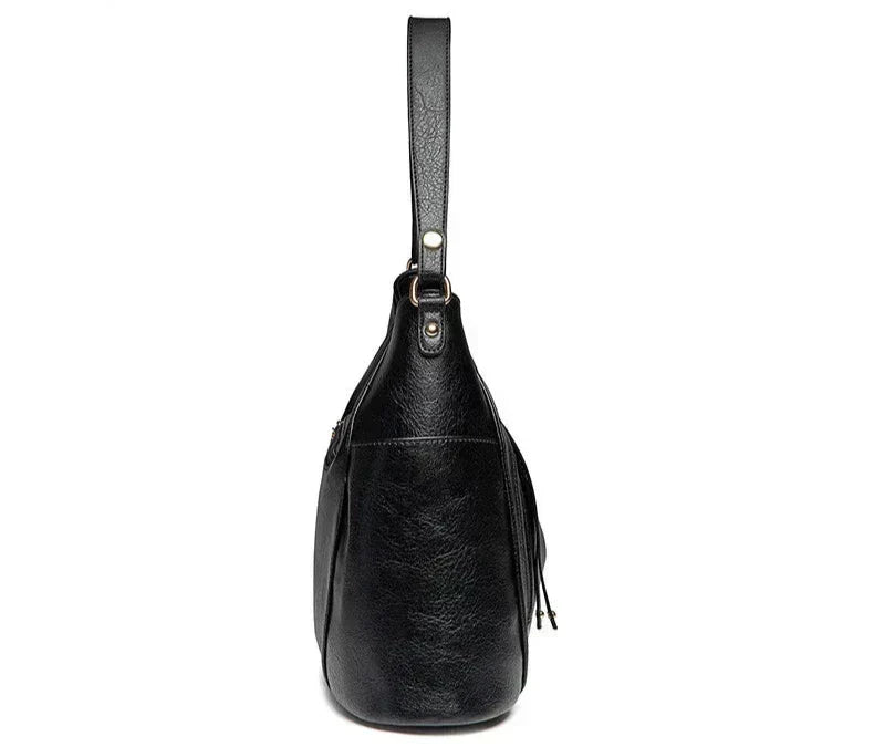 A woman wearing a fringed shoulder bag that sways gently as she walks through town.