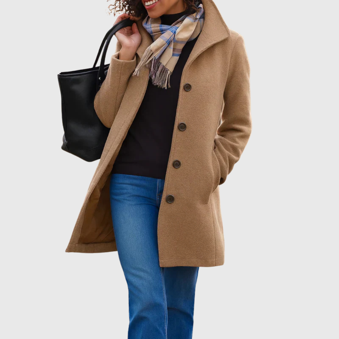 A woman wearing an elegant camel button-through coat over a sweater on a crisp fall day.
