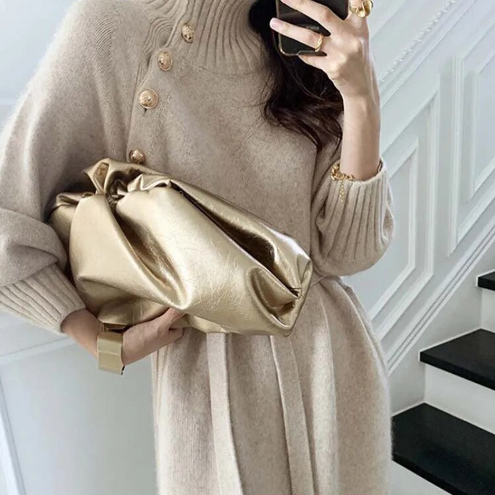 Woman in the Diana cosy wrap dress with gold-tone buttons and a waist tie, holding a warm drink at home.