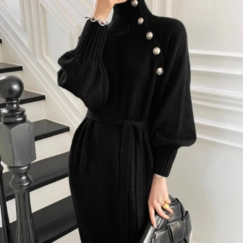 Woman in the Diana cosy wrap dress with gold-tone buttons and a waist tie, holding a warm drink at home.