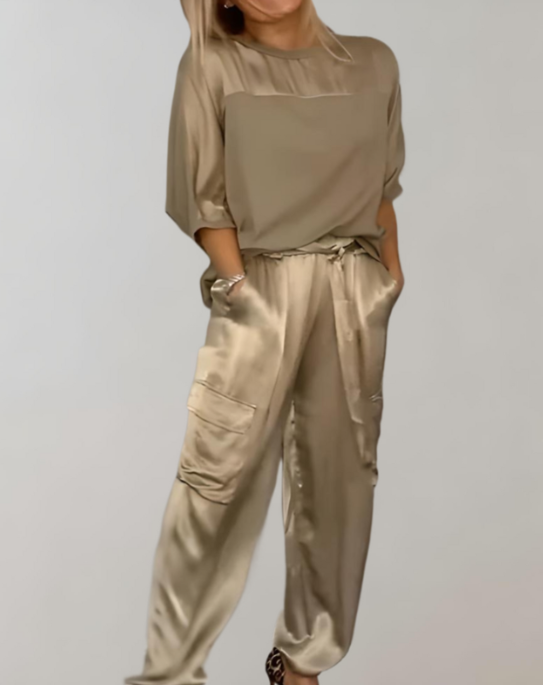 A woman wearing a silky-finish cargo top and pants lounge set with pockets.