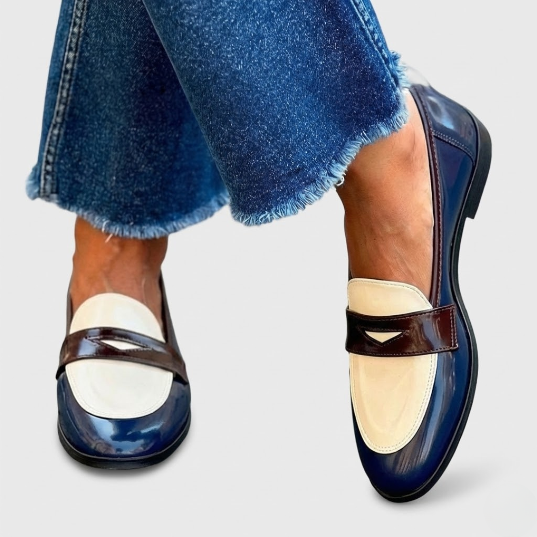 A woman wearing two-tone contrast loafers on a bright street.