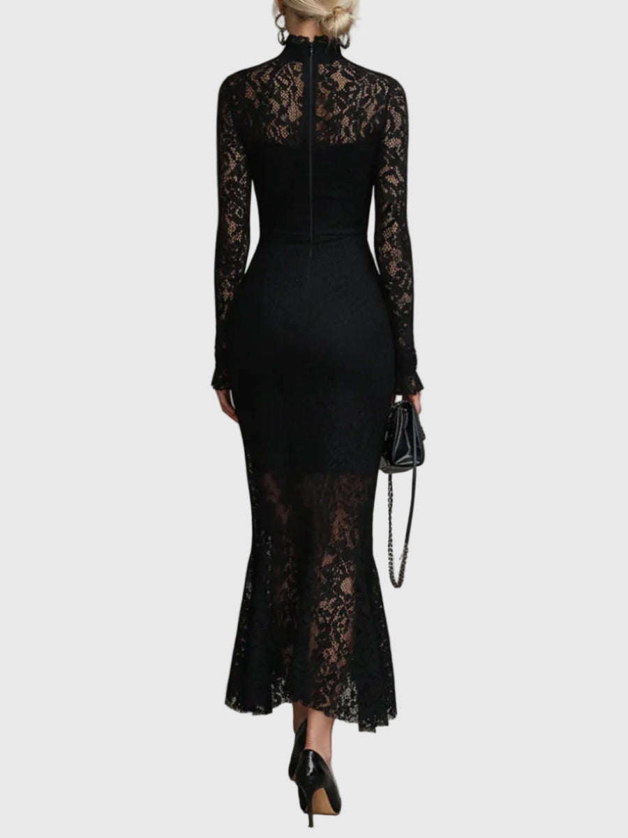 Woman wearing a fitted black maxi dress with a delicately textured skirt that flares out towards the hem.