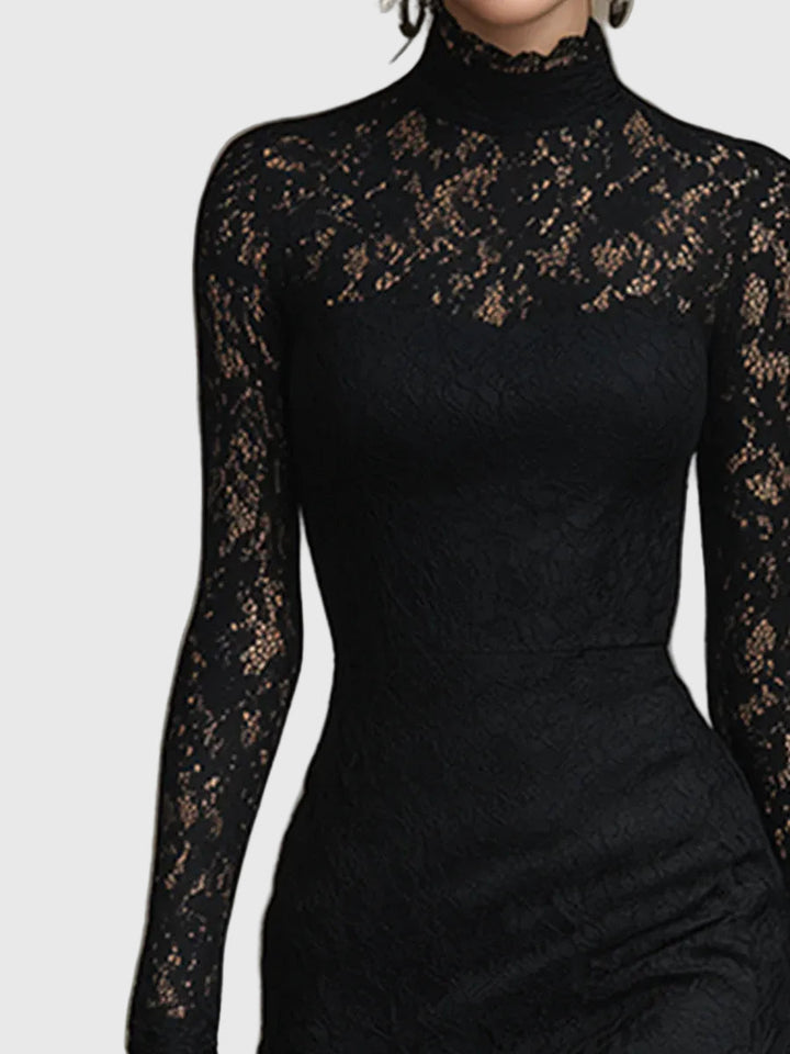 Woman wearing a fitted black maxi dress with a delicately textured skirt that flares out towards the hem.