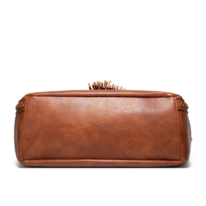 A woman carrying a soft tasselled shoulder bag while out for a walk in town.