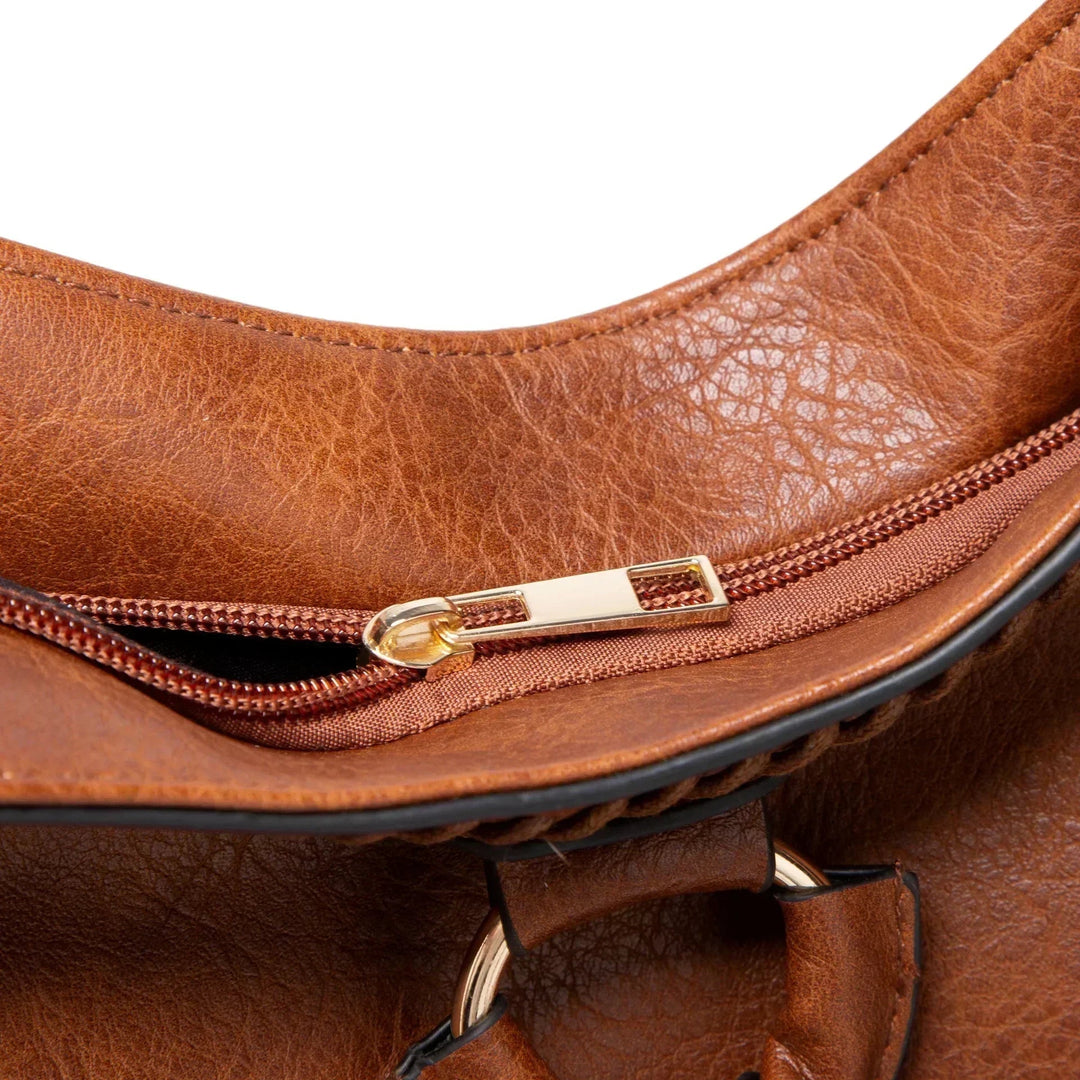 A woman carrying a soft tasselled shoulder bag while out for a walk in town.