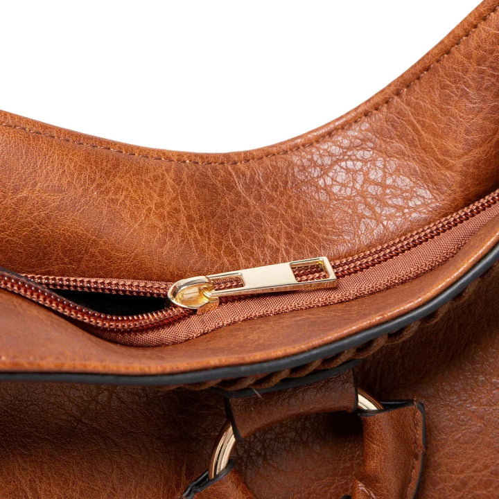 A woman carrying a soft tasselled shoulder bag while out for a walk in town.
