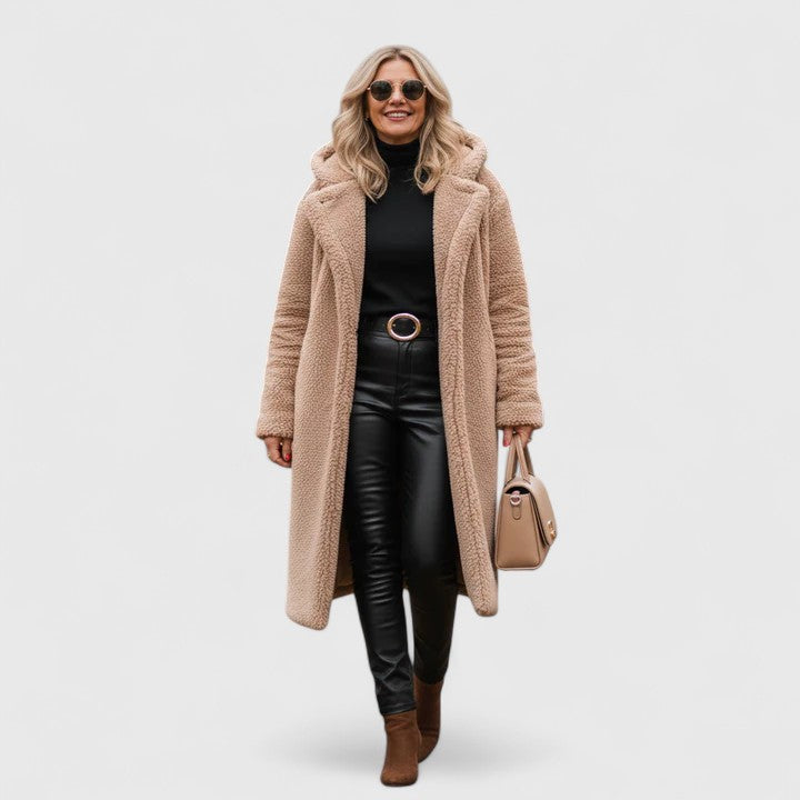 A woman wearing a long, softly textured hooded winter coat with an open front