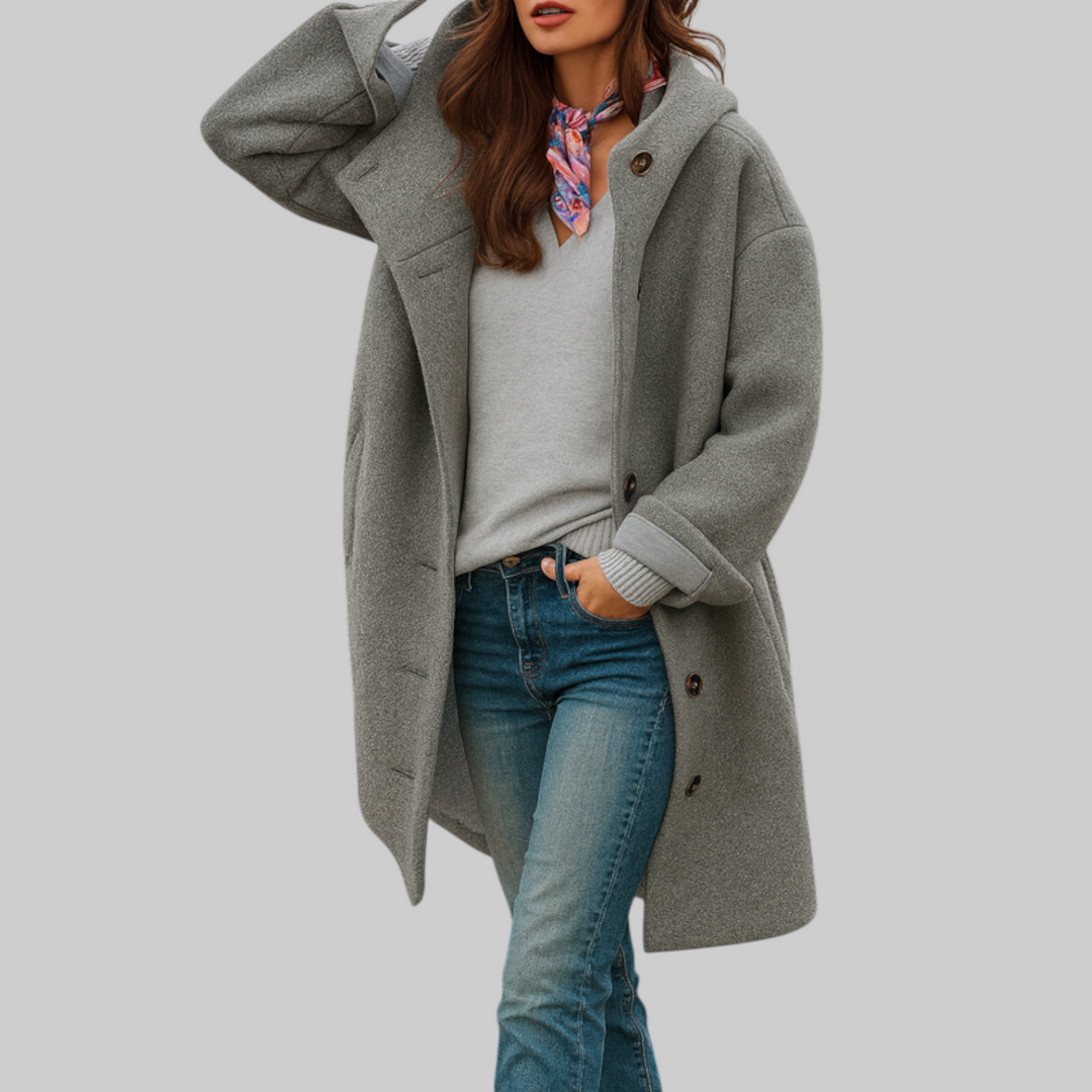 A woman wearing a hooded mid-length coat with wood-look buttons, hands in the side pockets.
