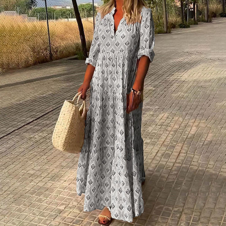 Woman wearing the Monica™ elegant boho maxi dress with a V-neckline and flowing skirt at a summer occasion.