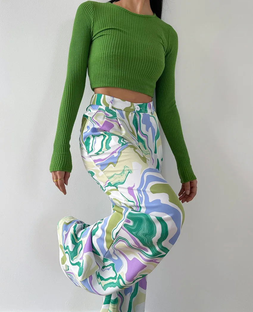 A woman wearing a bold abstract swirl-print shirt and matching wide-leg pants in the city