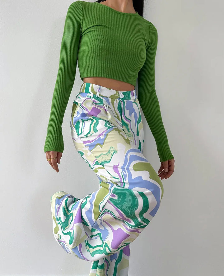 A woman wearing a bold abstract swirl-print shirt and matching wide-leg pants in the city