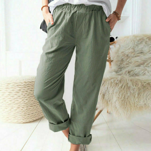 A woman standing relaxed in soft straight-leg pants with a clean, elegant everyday look.