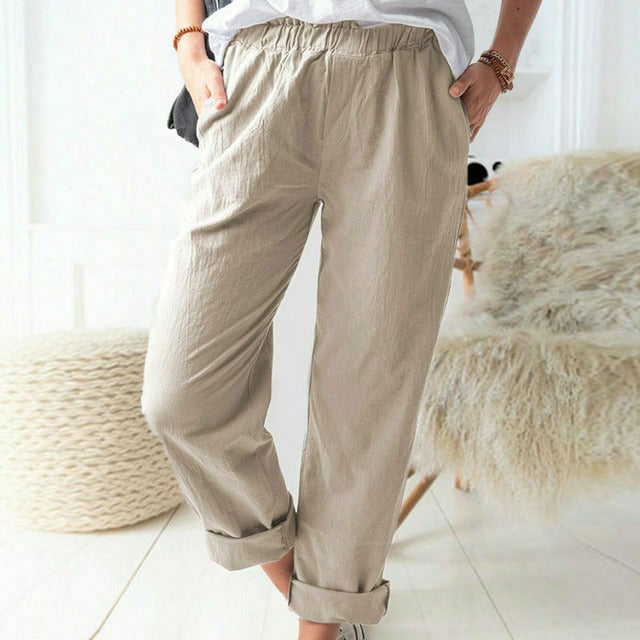 A woman standing relaxed in soft straight-leg pants with a clean, elegant everyday look.