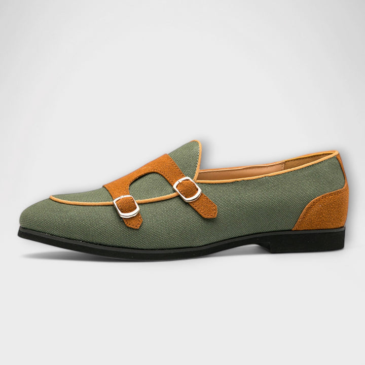 A woman wearing cream and tan round-toe slip-on loafers with twin gold buckle straps, walking with ease.