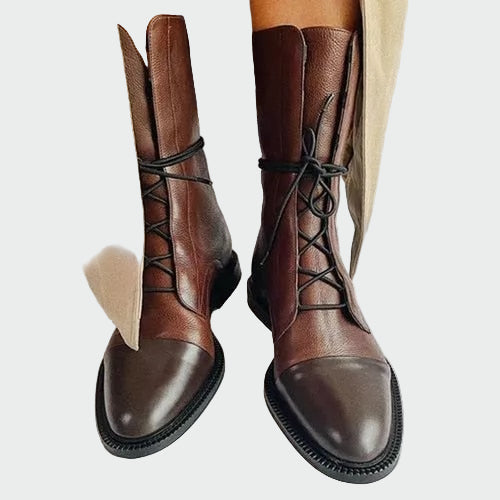 A woman in skinny jeans wearing slim black lace-up boots with a matte and glossy finish.