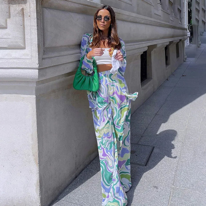 A woman wearing a bold abstract swirl-print shirt and matching wide-leg pants in the city