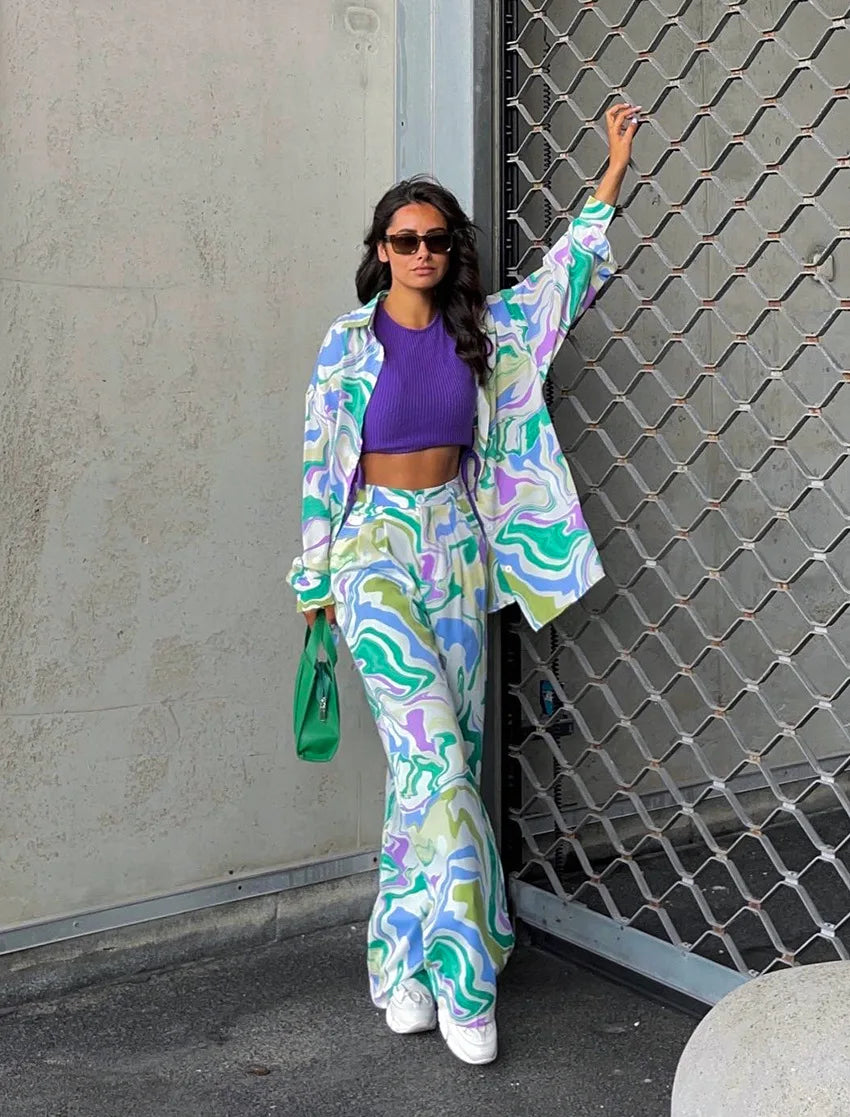 A woman wearing a bold abstract swirl-print shirt and matching wide-leg pants in the city