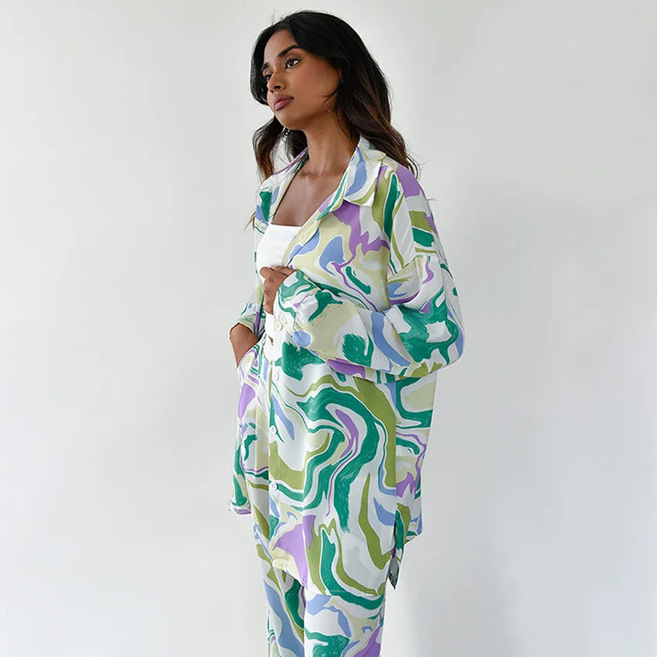 A woman wearing a bold abstract swirl-print shirt and matching wide-leg pants in the city