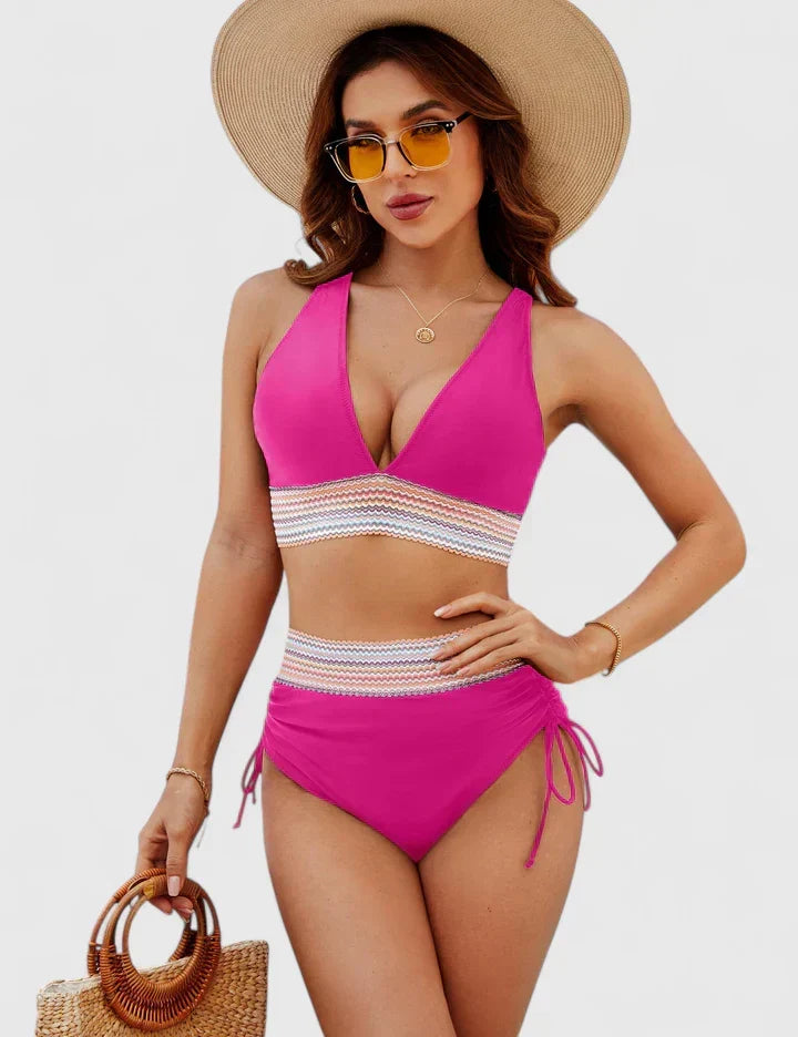 A woman wearing an elegant matching bikini set with a bold print, relaxed and confident on the beach.