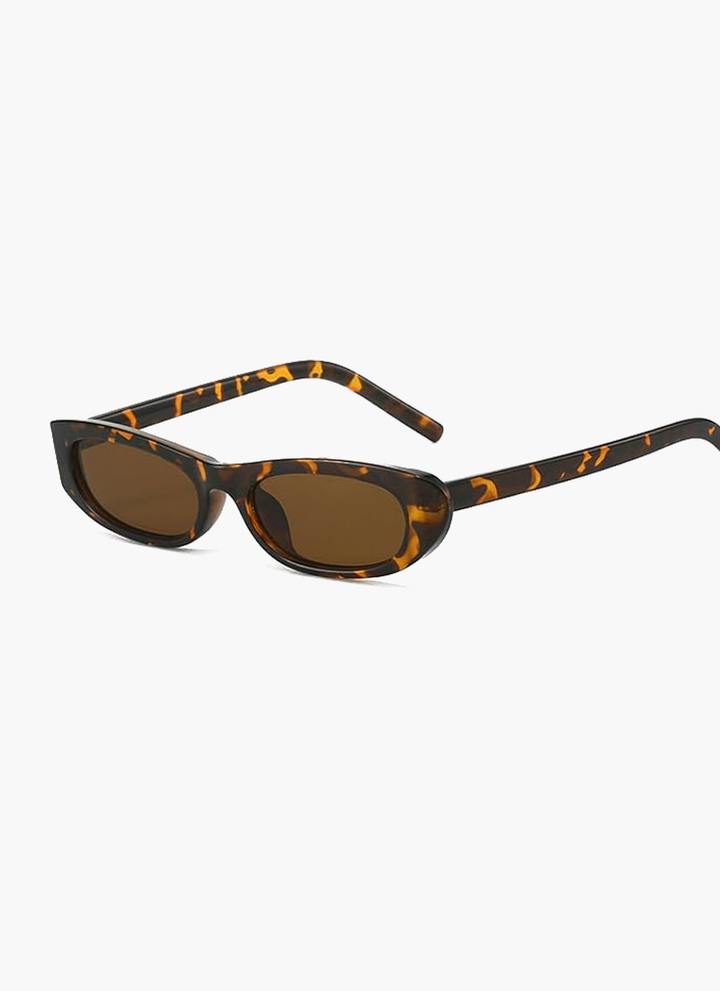 A woman wearing retro black oval cat-eye sunglasses on a sunny day.