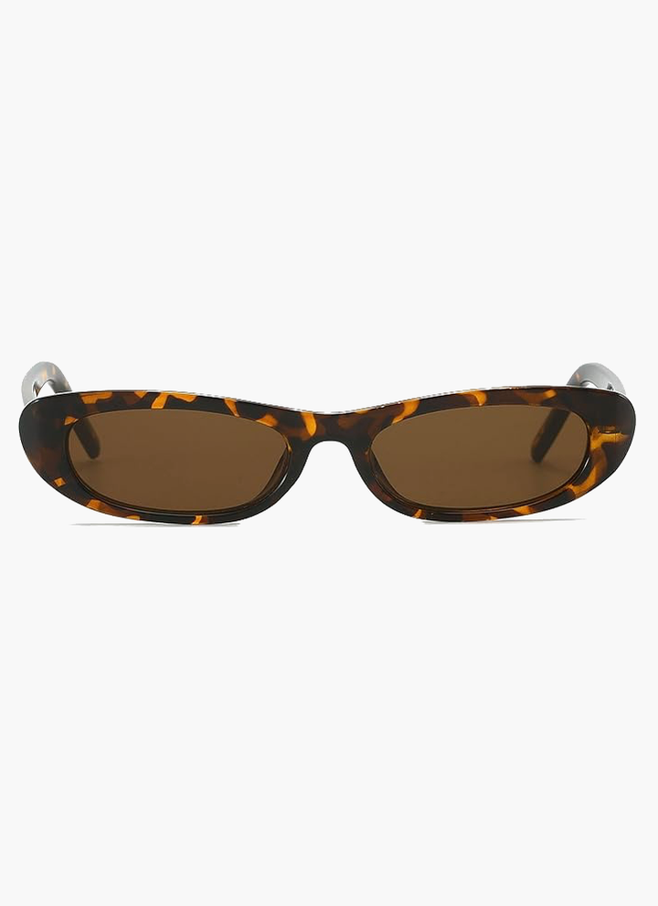 A woman wearing retro black oval cat-eye sunglasses on a sunny day.