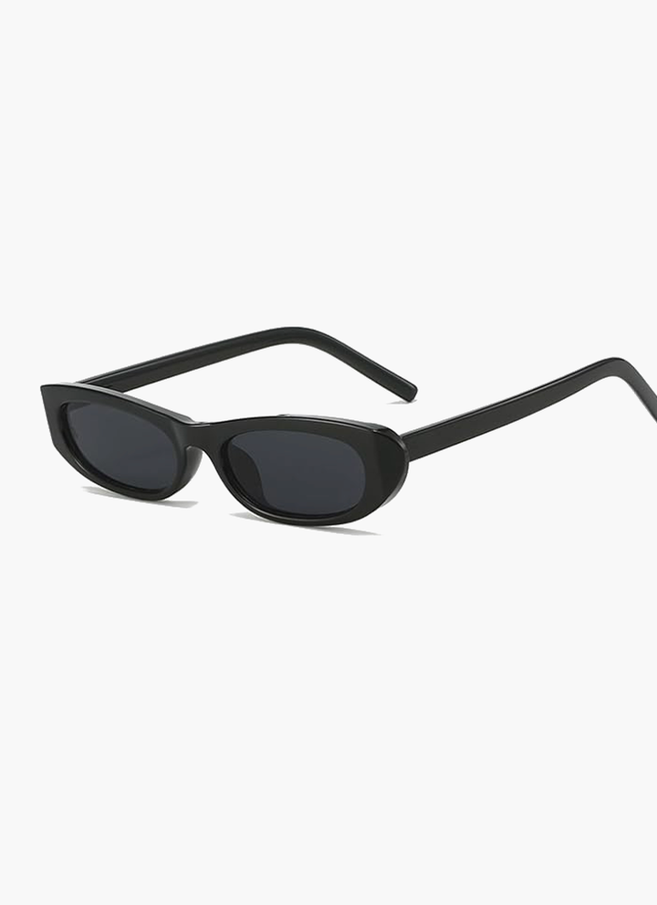 A woman wearing retro black oval cat-eye sunglasses on a sunny day.