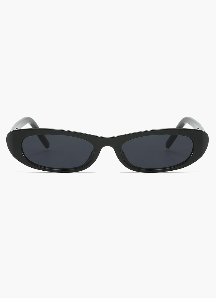 A woman wearing retro black oval cat-eye sunglasses on a sunny day.