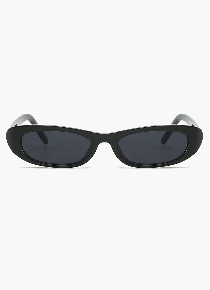 A woman wearing retro black oval cat-eye sunglasses on a sunny day.