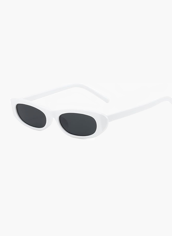 A woman wearing retro black oval cat-eye sunglasses on a sunny day.