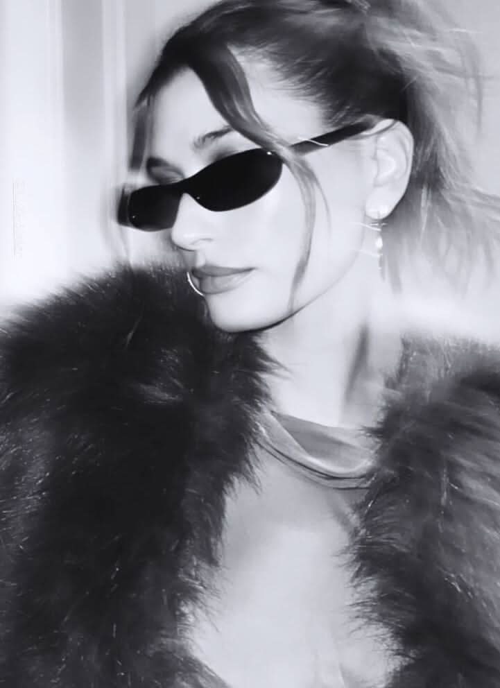 A woman wearing retro black oval cat-eye sunglasses on a sunny day.
