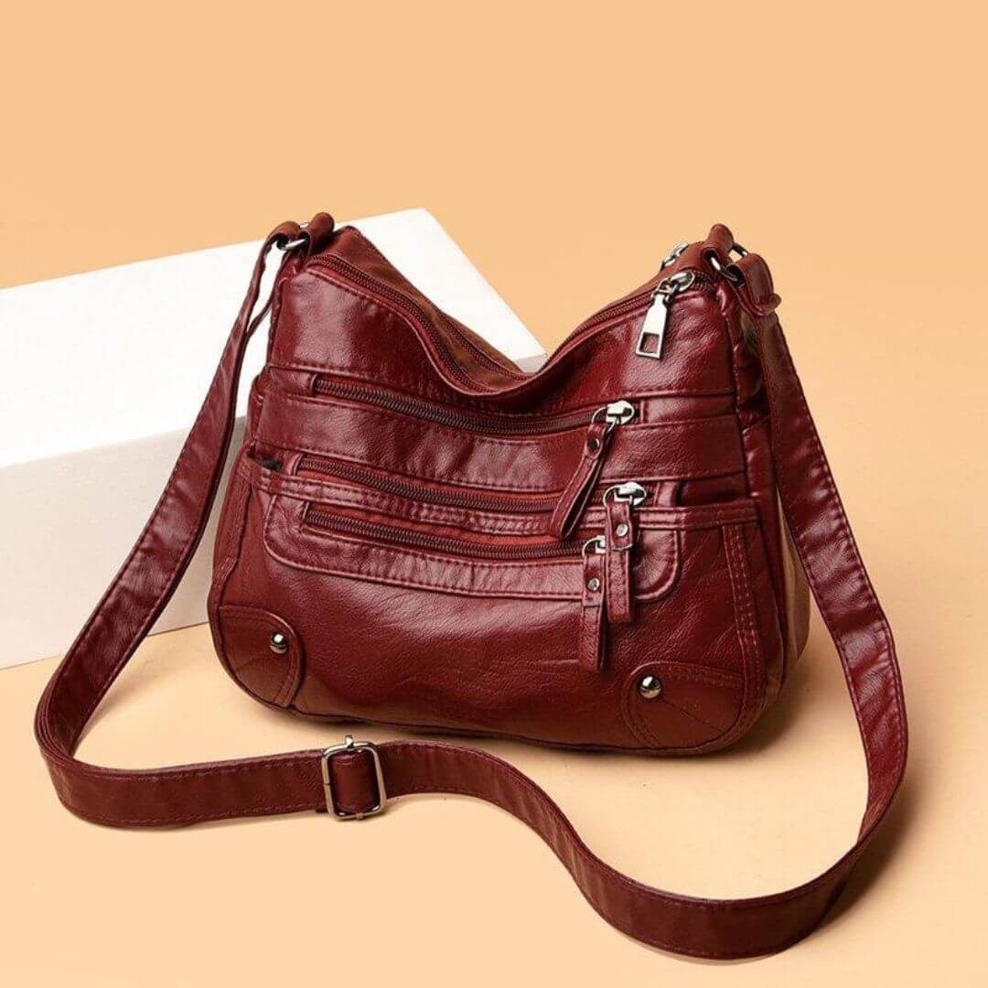 A woman wearing a soft elegant crossbody bag across her body while out shopping.
