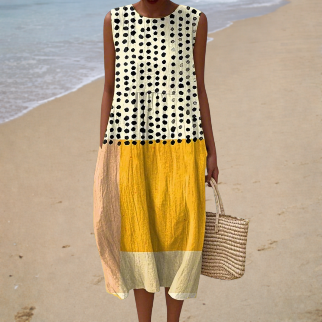 A woman wearing a sleeveless printed summer dress with a soft, flowing silhouette on a sunny day.
