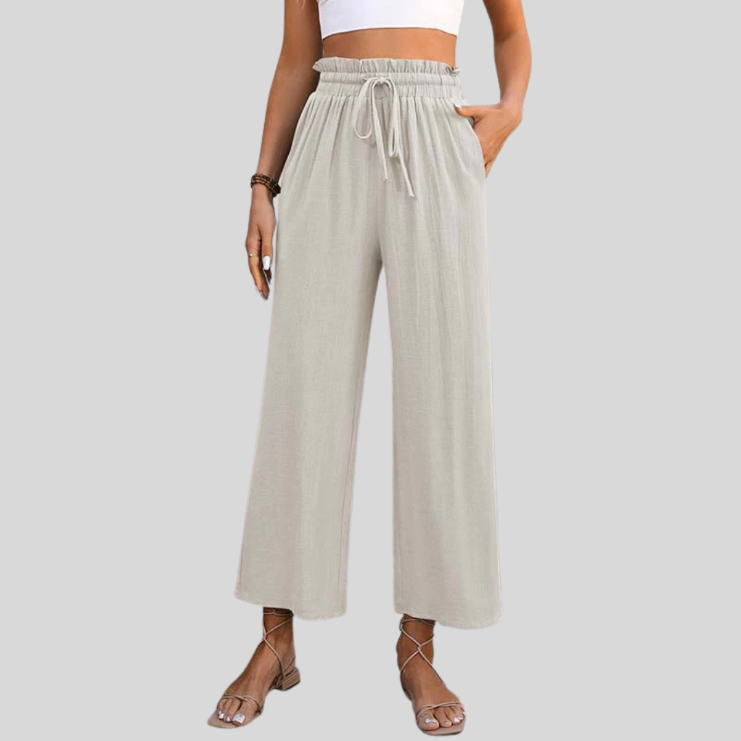 A woman in light cropped wide-leg pants styled with sandals for a relaxed summer look.