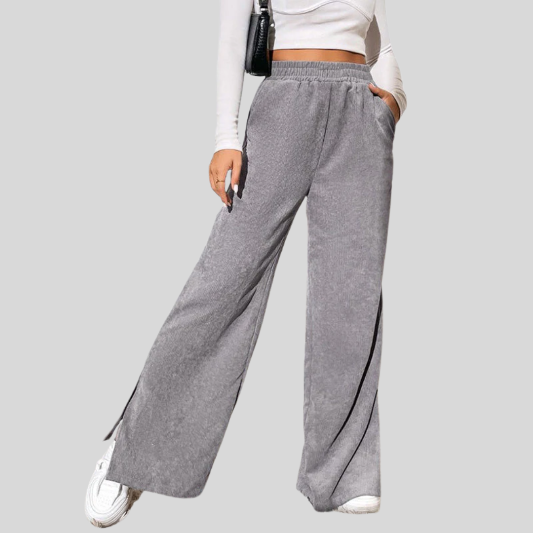 Woman wearing wide-leg ribbed joggers with a fitted top, relaxed at home.